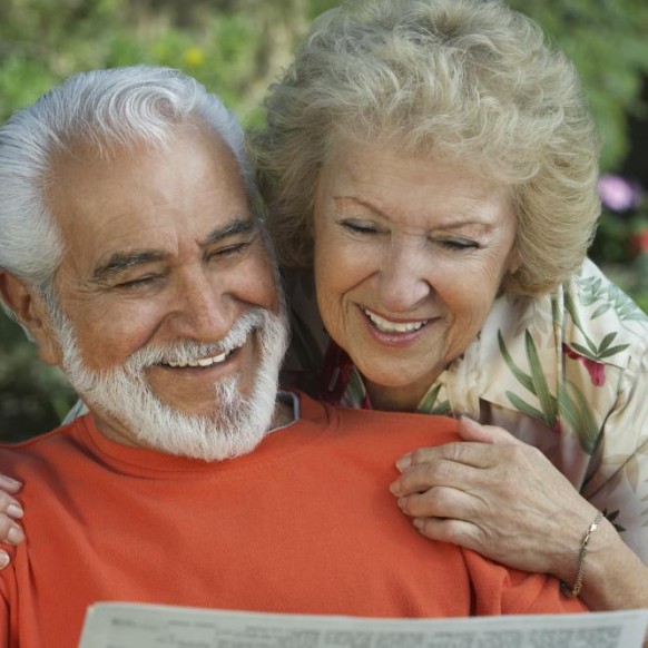 happy-senior-couple-reading-newspaper-together